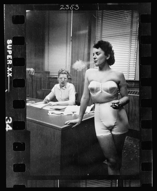 Woman_model_standing_in_an_office_smoking_while_modeling_undergarments.jpg